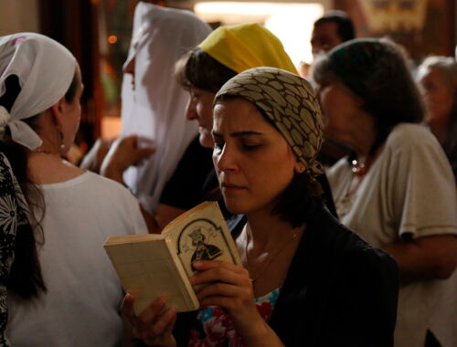 Frau mit Gebetsbuch in einer orthodoxen Kirche